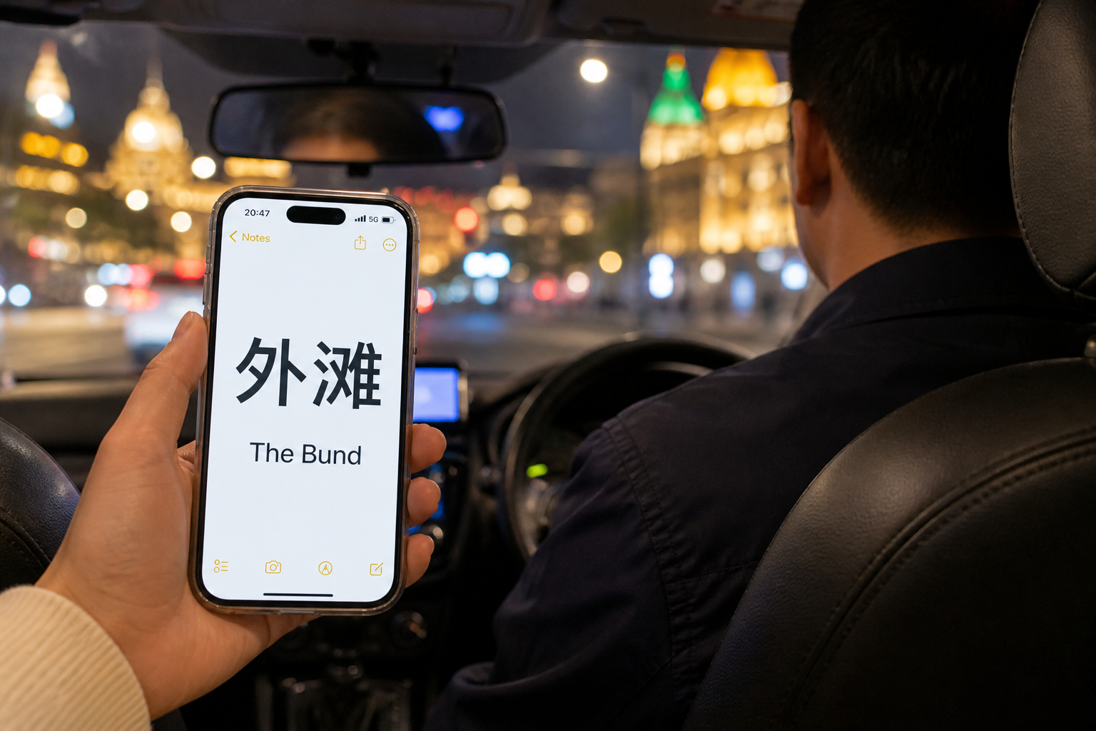Phone full-screen Chinese place name 外滩 shown to a taxi driver; faces and plates not shown.